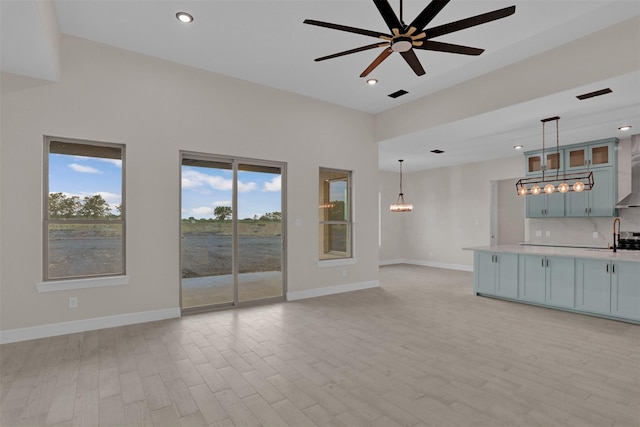 unfurnished living room featuring light hardwood / wood-style flooring and ceiling fan