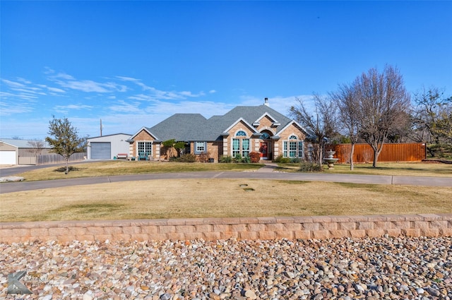 single story home with an outbuilding, a garage, and a front yard