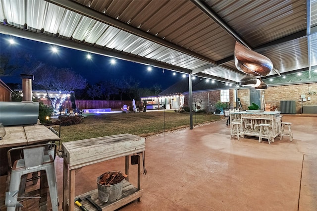 patio at twilight with a yard and grilling area