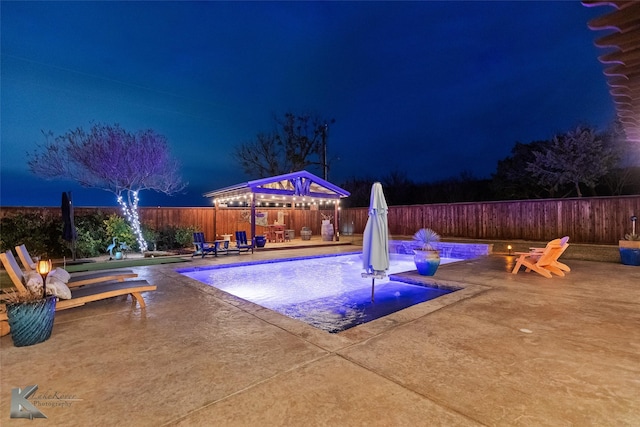 pool at twilight featuring a patio area