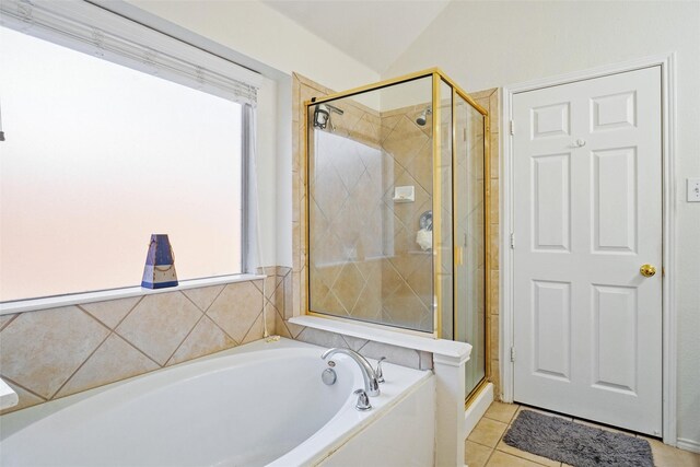 bathroom featuring tile patterned flooring, shower with separate bathtub, and vaulted ceiling