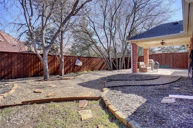 view of yard with ceiling fan and a patio