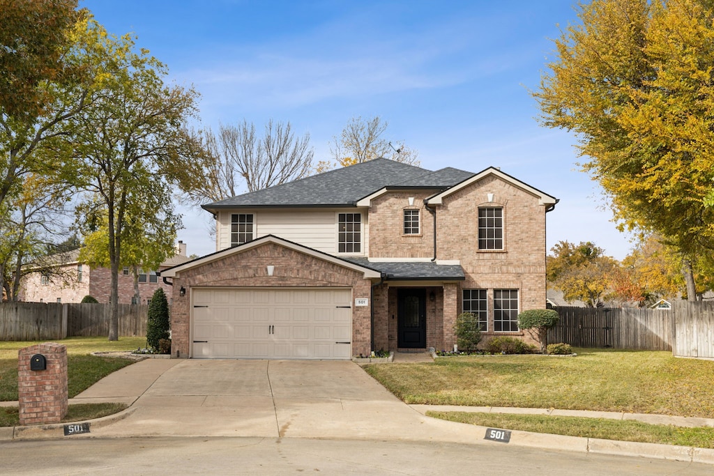 view of property with a garage and a front lawn