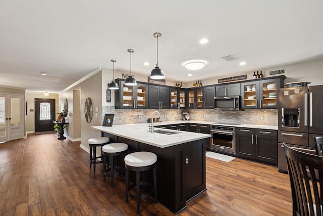 kitchen with sink, hanging light fixtures, a breakfast bar area, dark hardwood / wood-style flooring, and stainless steel appliances