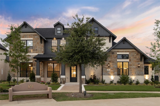 view of front of home featuring stone siding and a yard