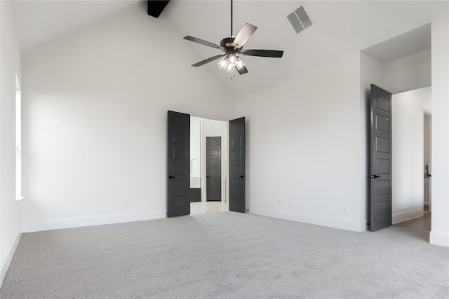 unfurnished bedroom with baseboards, high vaulted ceiling, visible vents, and light colored carpet