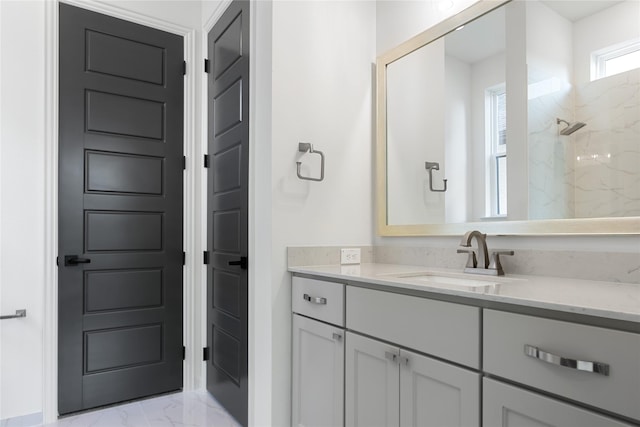 bathroom with marble finish floor, a marble finish shower, and vanity