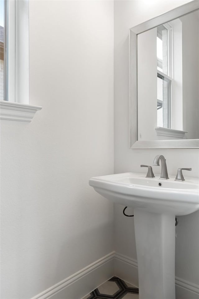 bathroom featuring baseboards and a sink