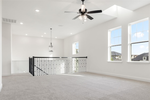 carpeted spare room with baseboards, ceiling fan with notable chandelier, visible vents, and recessed lighting