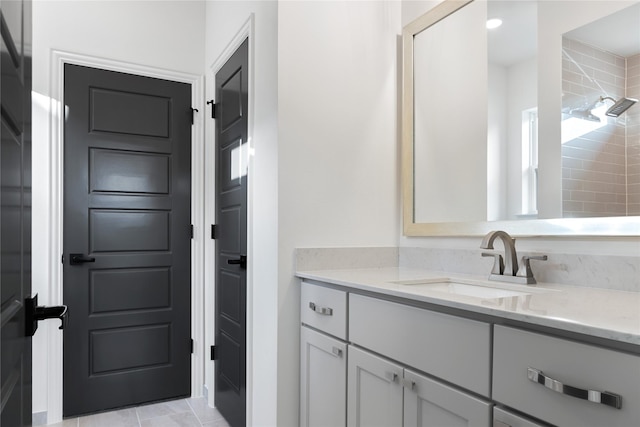 bathroom with a tile shower and vanity