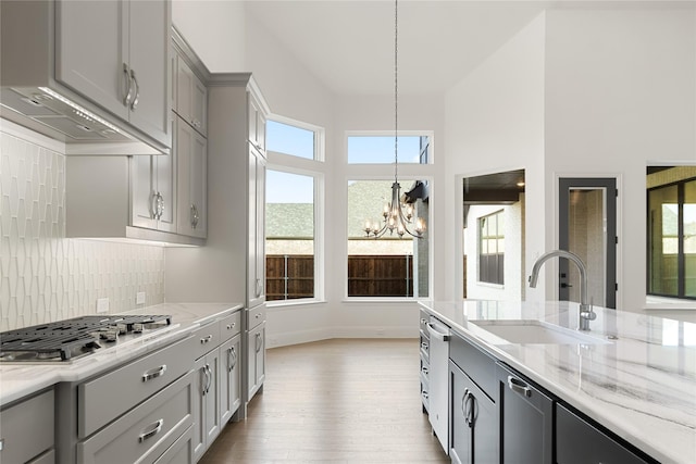 kitchen featuring plenty of natural light, stainless steel gas cooktop, a sink, and gray cabinetry