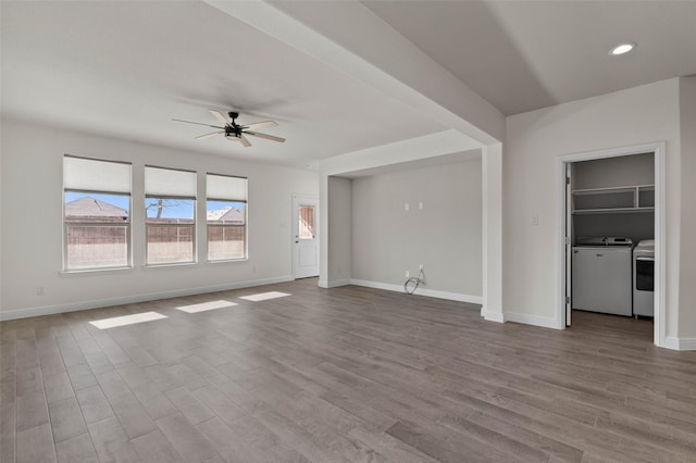 unfurnished living room featuring ceiling fan, light hardwood / wood-style flooring, and washer and dryer