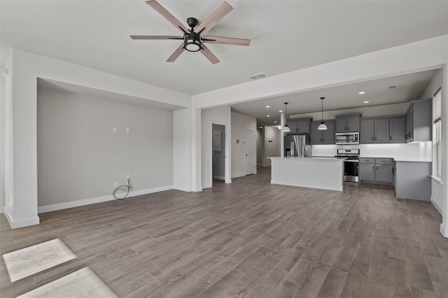 unfurnished living room featuring hardwood / wood-style floors and ceiling fan