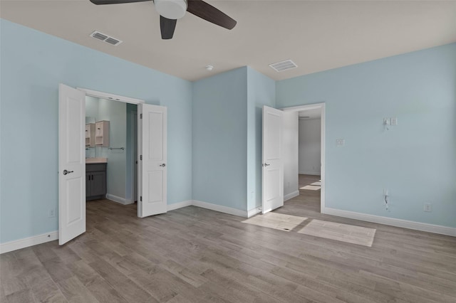 unfurnished bedroom featuring ceiling fan, light hardwood / wood-style floors, and ensuite bath