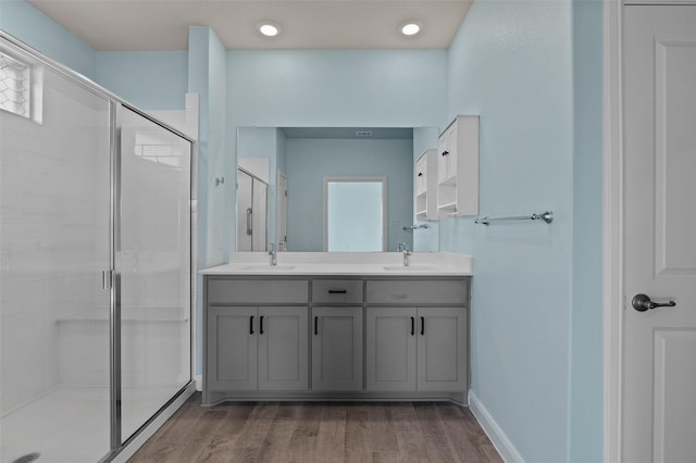 bathroom with a wealth of natural light, a shower with door, vanity, and hardwood / wood-style flooring