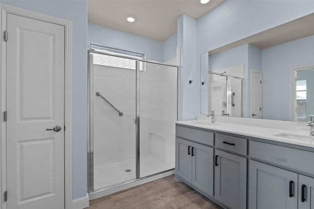 bathroom featuring plenty of natural light, vanity, hardwood / wood-style floors, and walk in shower