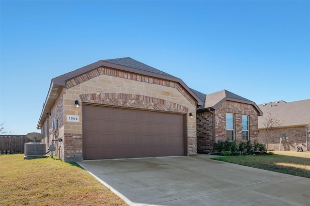 view of front of home featuring central AC unit, a garage, and a front yard