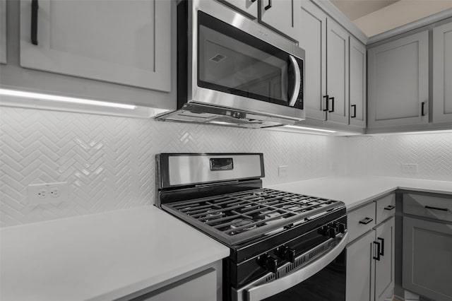 kitchen featuring tasteful backsplash, gray cabinets, and appliances with stainless steel finishes