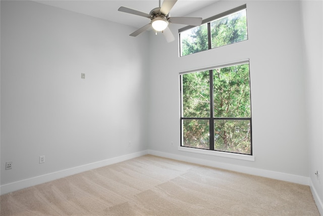 carpeted spare room with ceiling fan and a healthy amount of sunlight