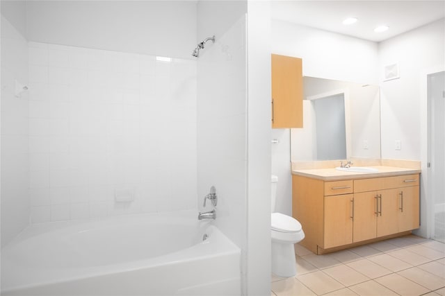 full bathroom with tile patterned floors, vanity, tiled shower / bath, and toilet