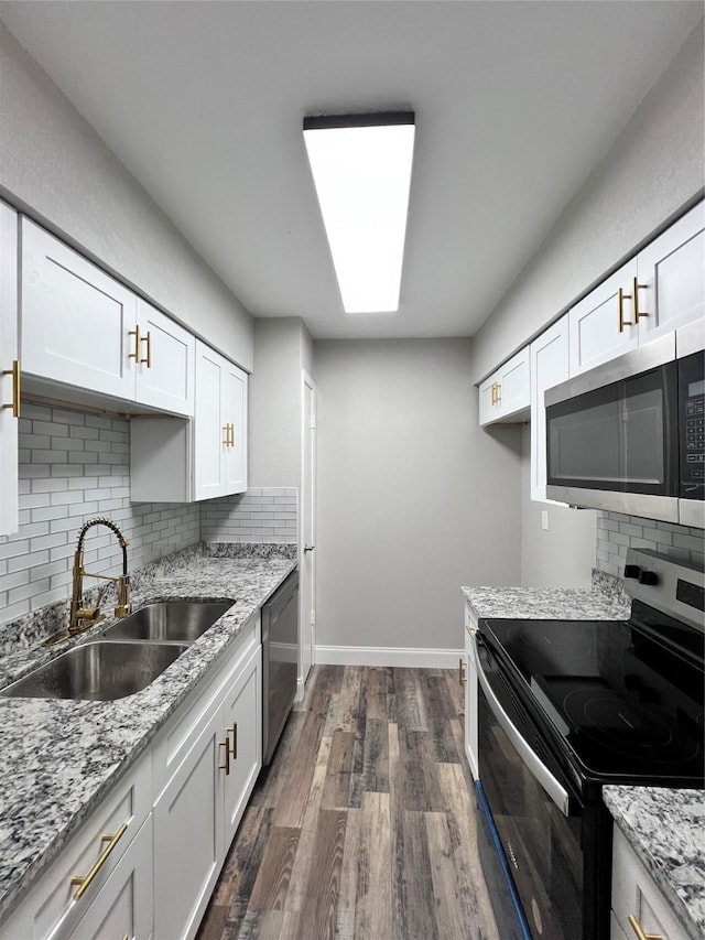 kitchen featuring white cabinetry, sink, stainless steel appliances, dark hardwood / wood-style floors, and backsplash