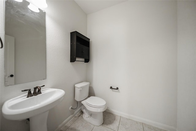 bathroom with sink, toilet, and tile patterned flooring