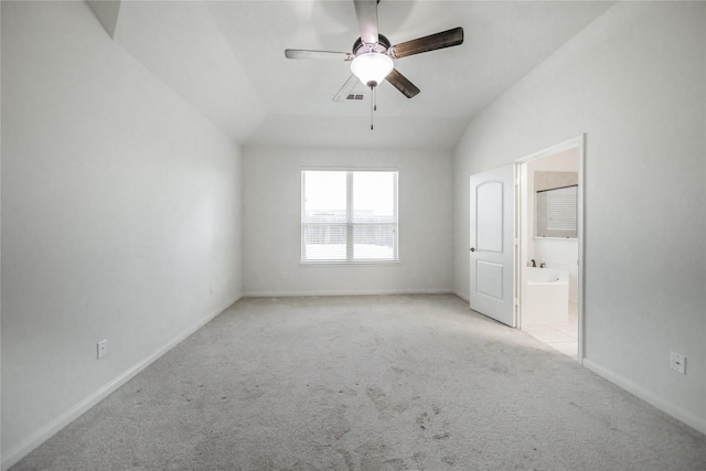 unfurnished bedroom with ceiling fan, lofted ceiling, light colored carpet, and ensuite bath