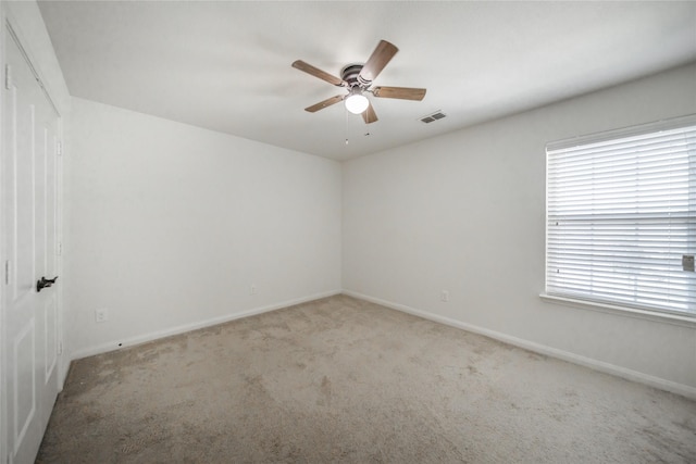 carpeted spare room with ceiling fan