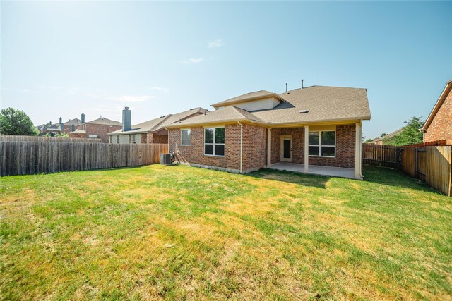 back of house with central AC, a lawn, and a patio area