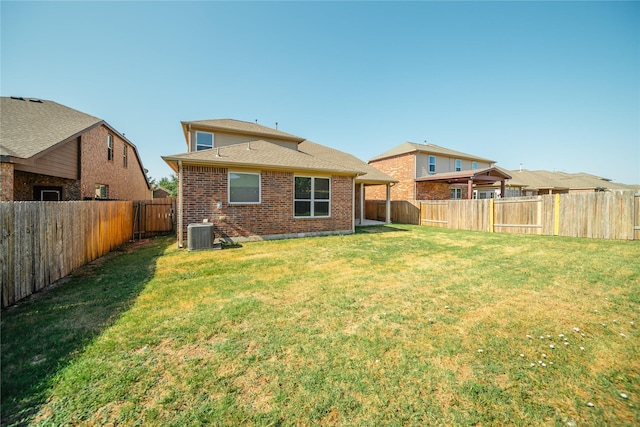 back of property featuring cooling unit and a lawn