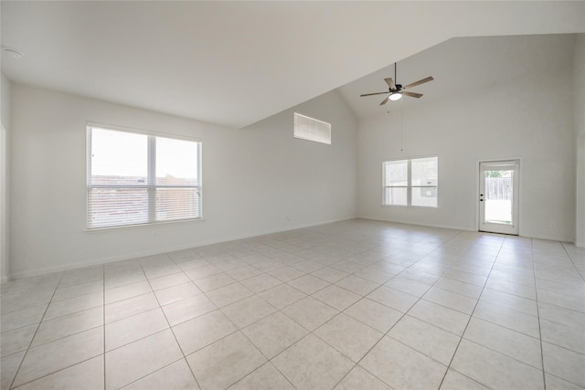 tiled empty room with high vaulted ceiling and ceiling fan