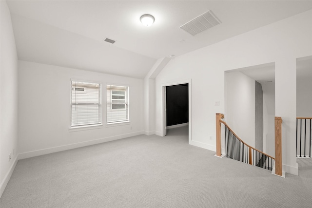 carpeted spare room with lofted ceiling