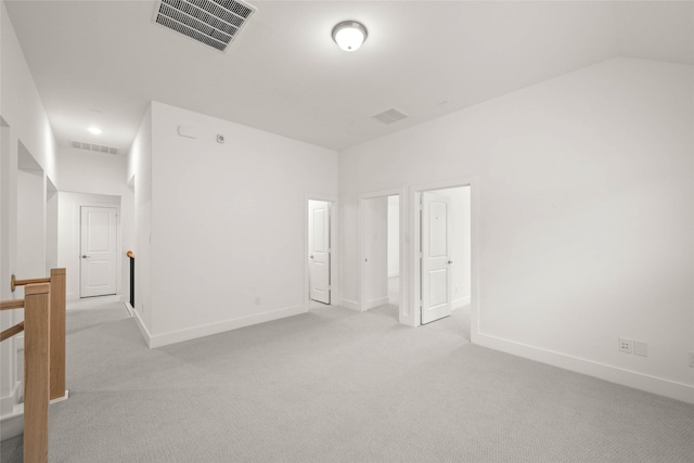 empty room featuring light carpet and lofted ceiling