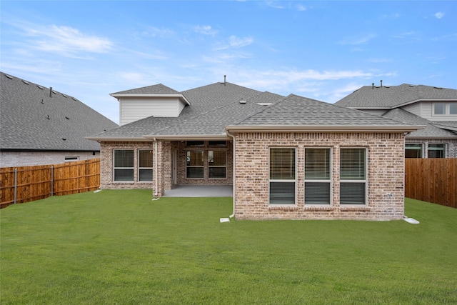 rear view of house featuring a yard and a patio