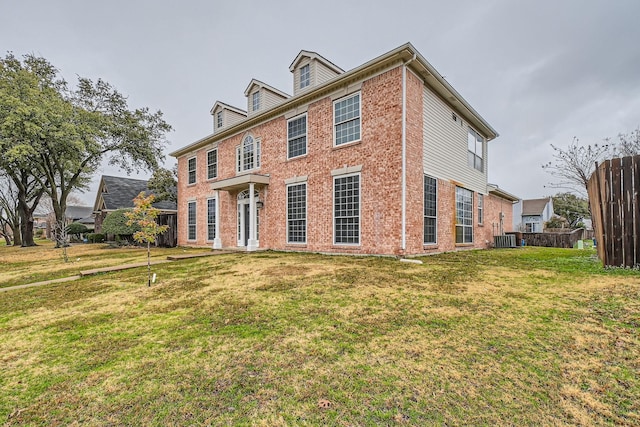 colonial inspired home featuring cooling unit and a front lawn