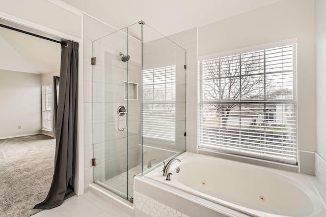 bathroom featuring independent shower and bath and a healthy amount of sunlight