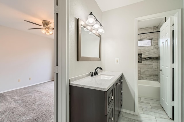 bathroom with tiled shower / bath combo, vanity, and ceiling fan