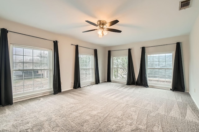 carpeted spare room featuring ceiling fan