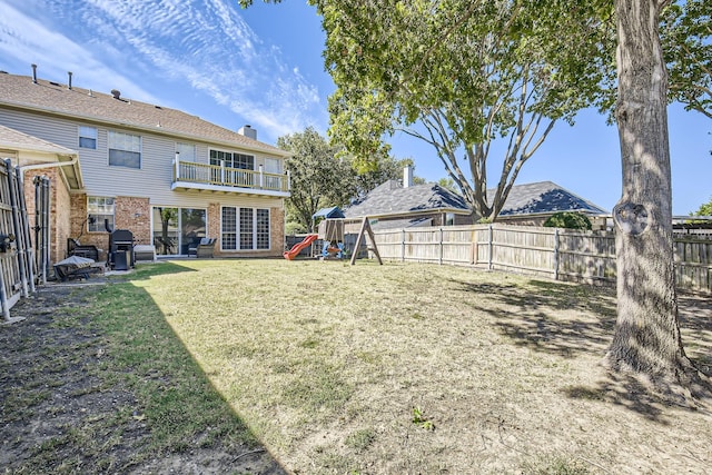 view of yard with a balcony and a playground