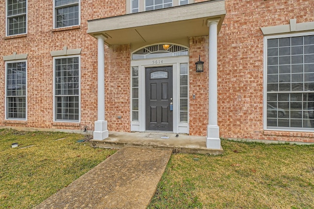 entrance to property featuring a lawn