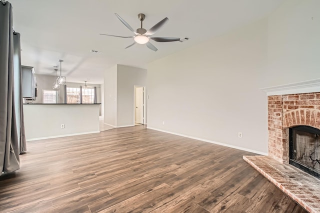 unfurnished living room with hardwood / wood-style flooring, ceiling fan, a fireplace, and high vaulted ceiling