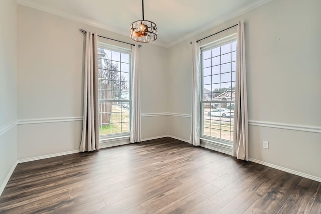 unfurnished room with crown molding, a healthy amount of sunlight, dark hardwood / wood-style flooring, and an inviting chandelier