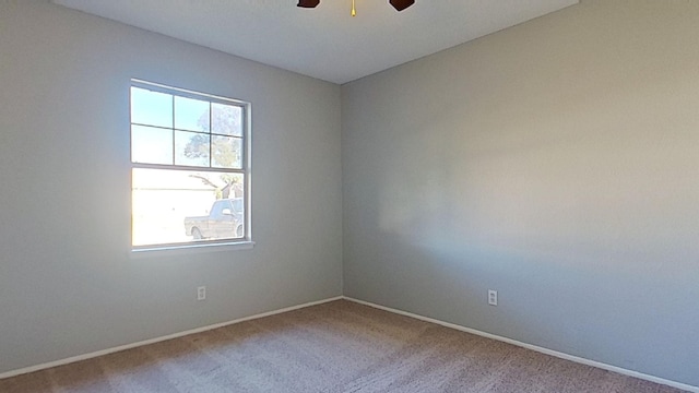 carpeted spare room featuring ceiling fan