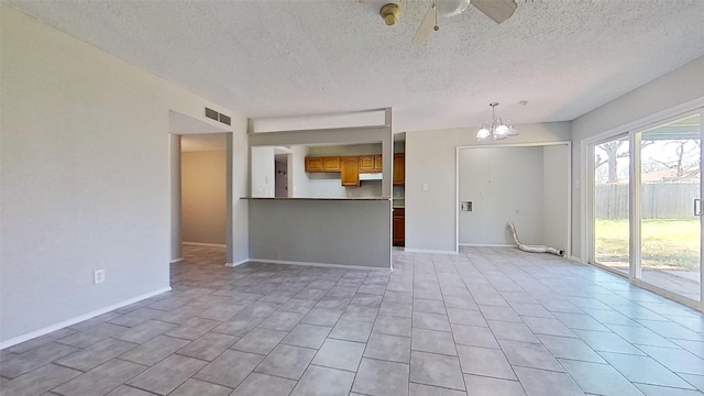 unfurnished living room featuring ceiling fan with notable chandelier and a textured ceiling