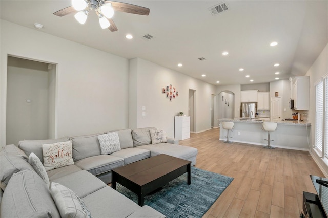 living room featuring light wood-type flooring and ceiling fan