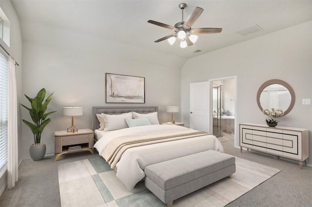 bedroom featuring ceiling fan, light colored carpet, ensuite bathroom, and vaulted ceiling