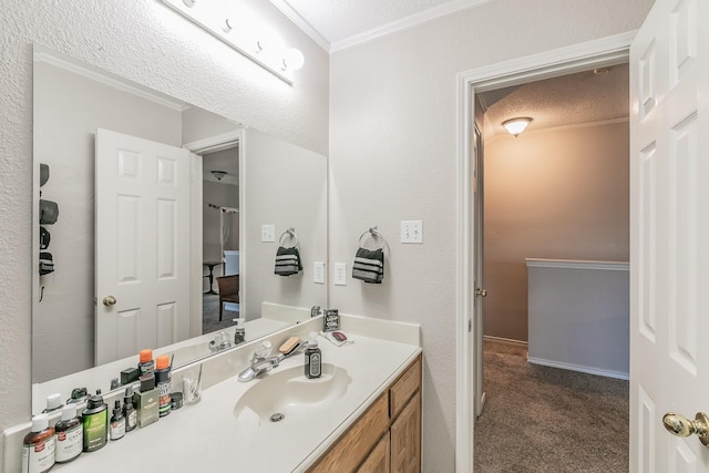 bathroom featuring vanity, crown molding, and a textured ceiling