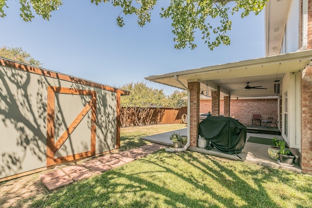 view of yard featuring a patio area, ceiling fan, and a storage shed