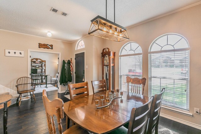 dining room with dark hardwood / wood-style flooring, ornamental molding, a textured ceiling, and an inviting chandelier