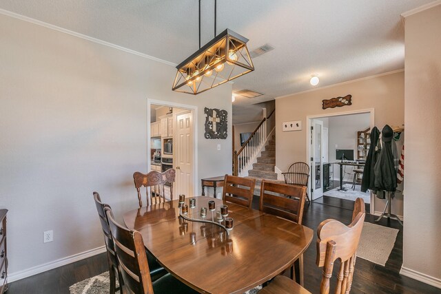 dining room with a textured ceiling, a notable chandelier, ornamental molding, and dark wood-type flooring